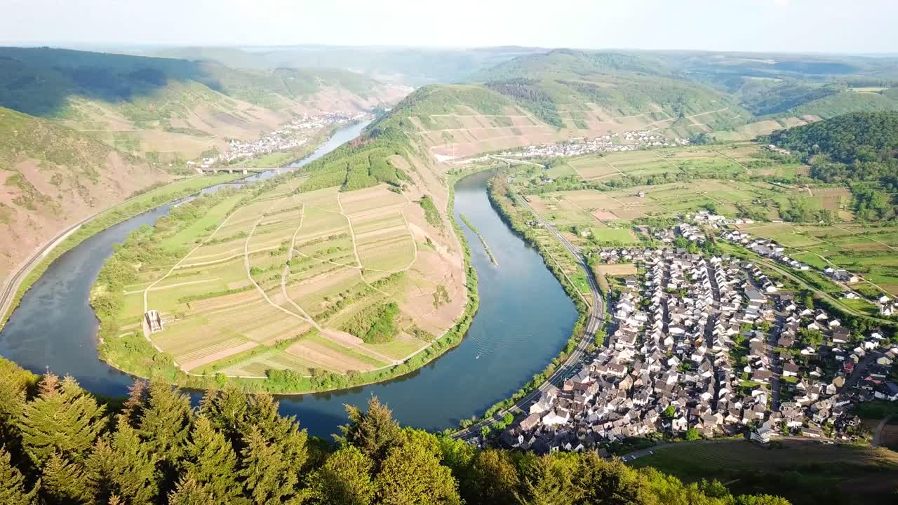 모젤스루이프 (mosel-schleife) 의 공중 풍경: 모젤 강 (moselle) 의 휘어지는 모습, 테라스 된 포도원, 굴곡 된 언덕 사이에 자리 잡은 그림 같은 마을, 울창한 숲.