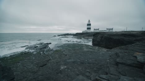 lighthouse near black cliffs on the shoreline