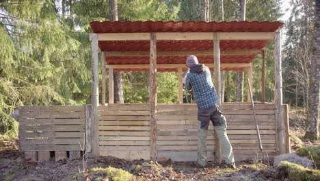 SLOW-MOTION-WIDE---Hipster-man-empties-the-compost-bucket-at-the-compost-house