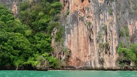 vibrant turquoise waters meet majestic cliffs adorned with lush greenery.