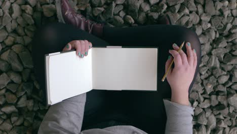 Girl-holds-her-sketchbook-and-pencil-to-get-ready-to-draw