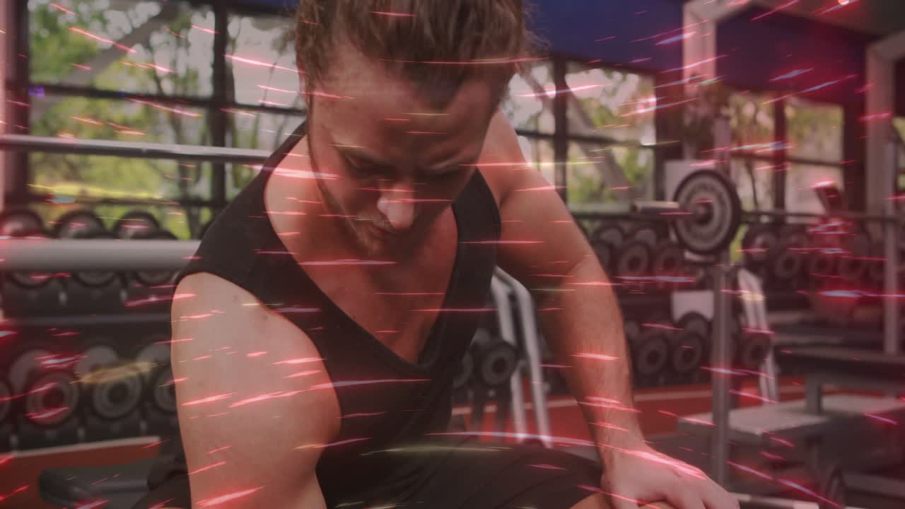 Uomo che completa una ripetizione con i manubri in palestra, controllando la forma e sorridendo, con una striscia rossa sovrapposta all'inquadratura
