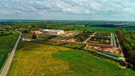 pilsrundale, latvia- aerial forwarding shot of rundale palace and beautiful green park around it at daytime on a cloudy day