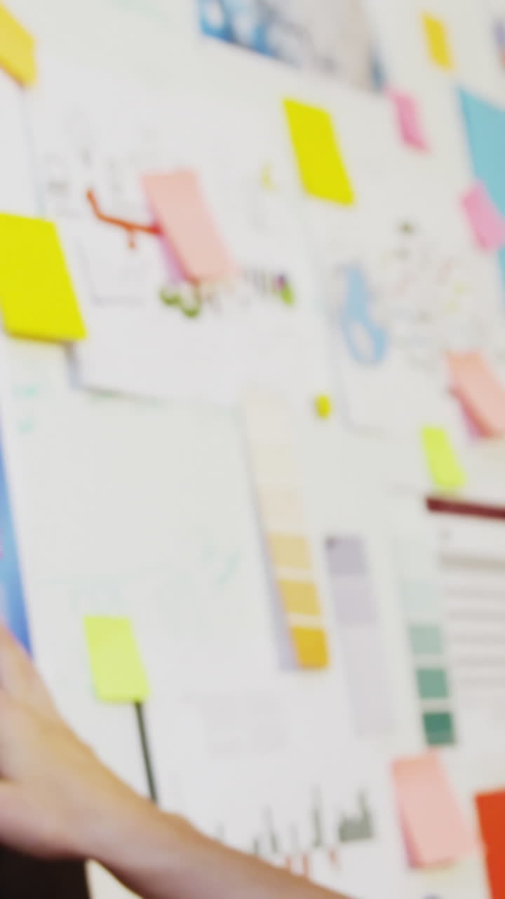 mujer de negocios mirando notas adhesivas en la pizarra