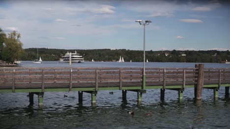 plano general de un barco en un lago acercándose al muelle en primer plano