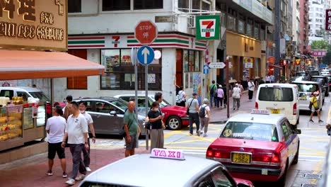 pedestrians and vehicles navigate a bustling intersection