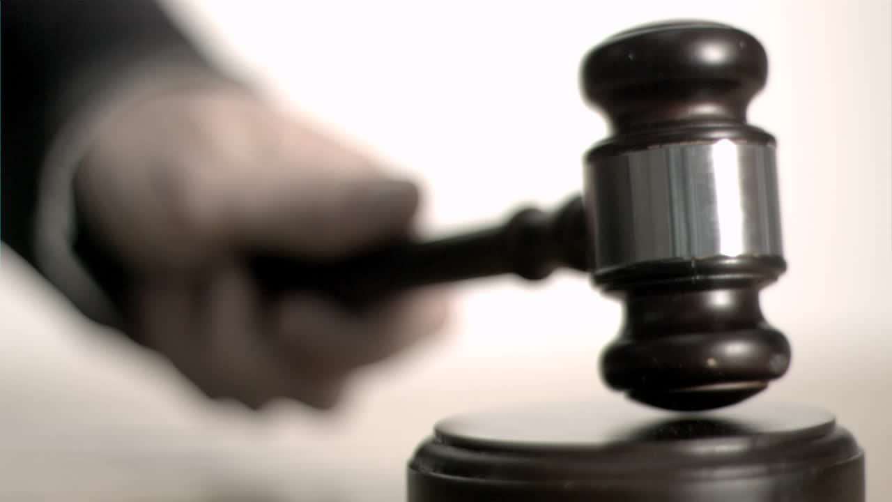 Mans hand striking in super slow motion a gavel 