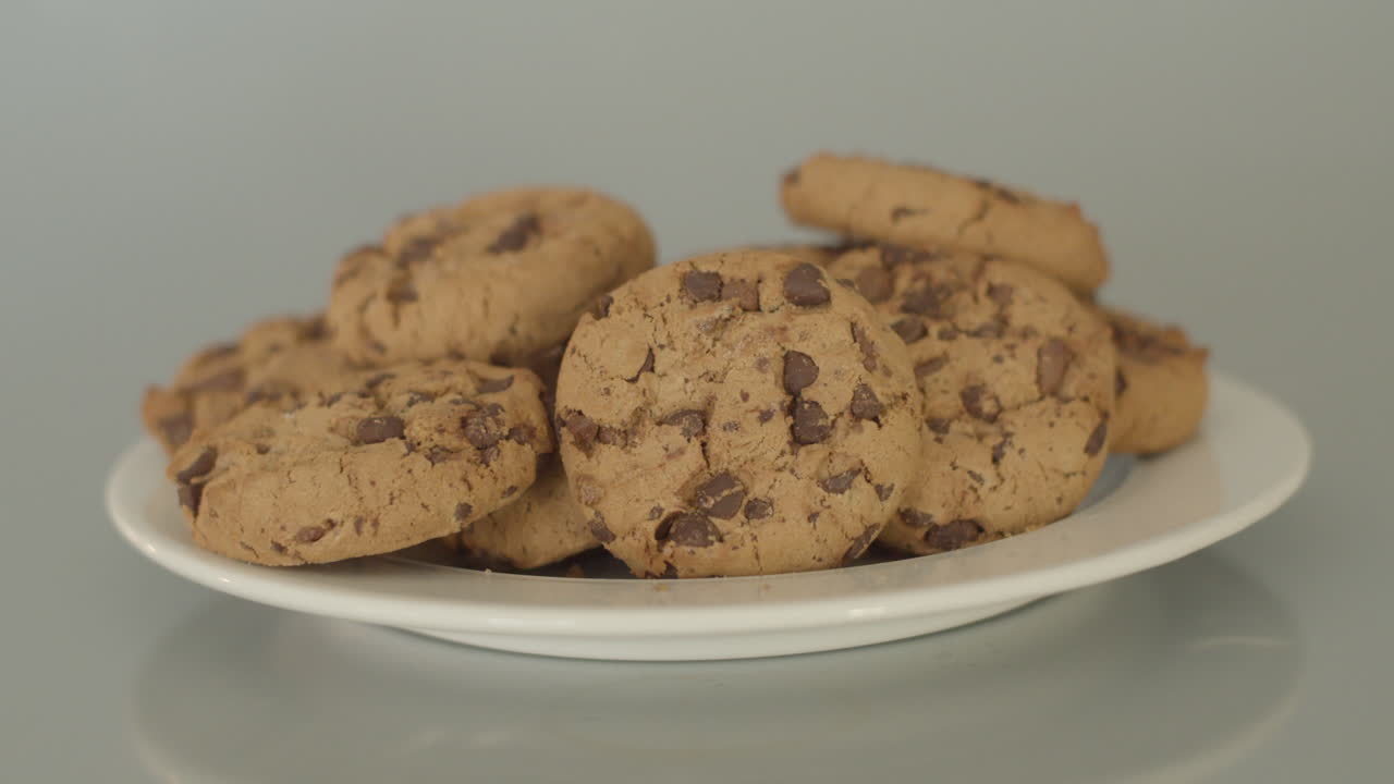 Dolly in of chocolate chip cookies on a white plate