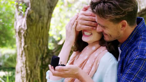 Man-covering-woman-eyes-while-giving-her-surprise-gift