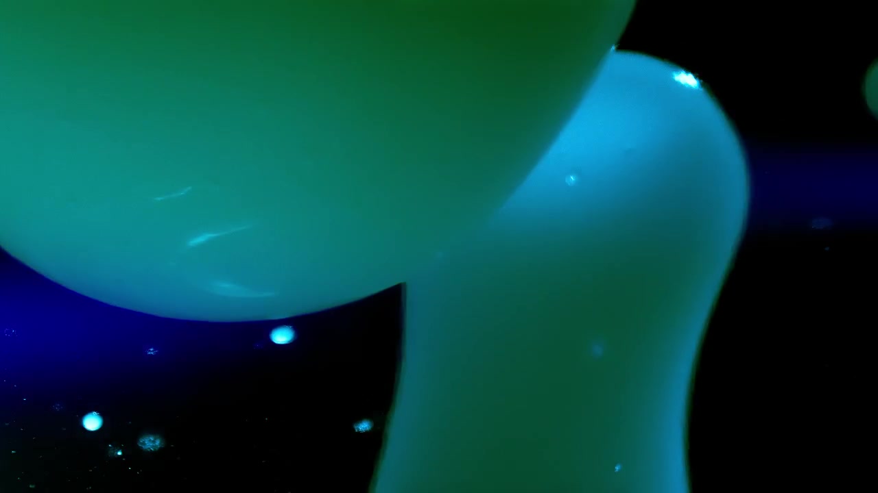 Bolle di lava verdi che scorrono in un liquido su sfondo nero.
