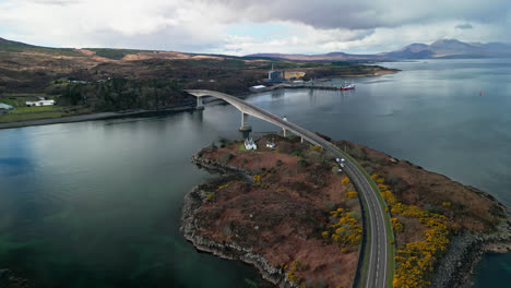 aerial pullback reveals bend on iconic skye bridge road in scotland