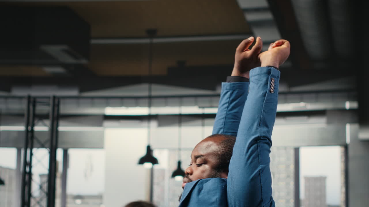 Vertical Video Black businessman correcting his bad posture at the workstation