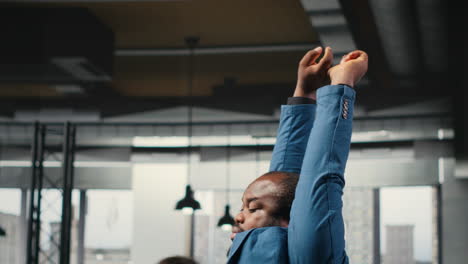 vertical video black businessman correcting his bad posture at the workstation