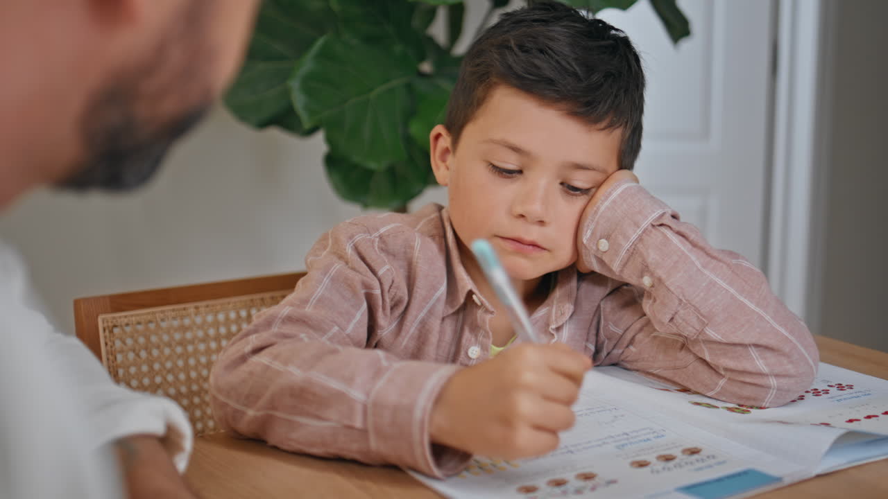 Learning kid listening father writing at home closeup. Pupil doing homework
