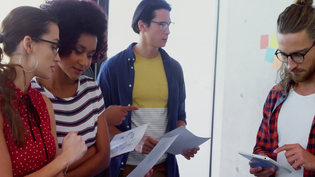 colegas discutiendo sobre documentos mientras usan una tableta digital 4k