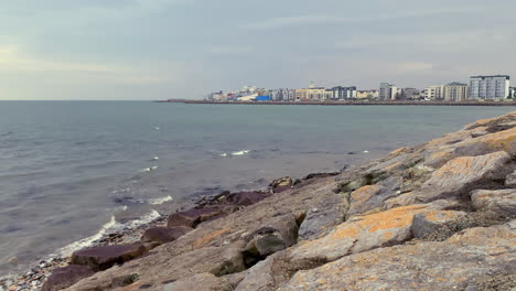Salthill's waterfront buildings line Galway Bay's shore, viewed across coastal rocks