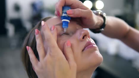 mujer con gotas para los ojos. primer plano de una hermosa chica, maquillaje maestro aplicando gotas para los ojos en sus ojos. joven modelo femenina con natural