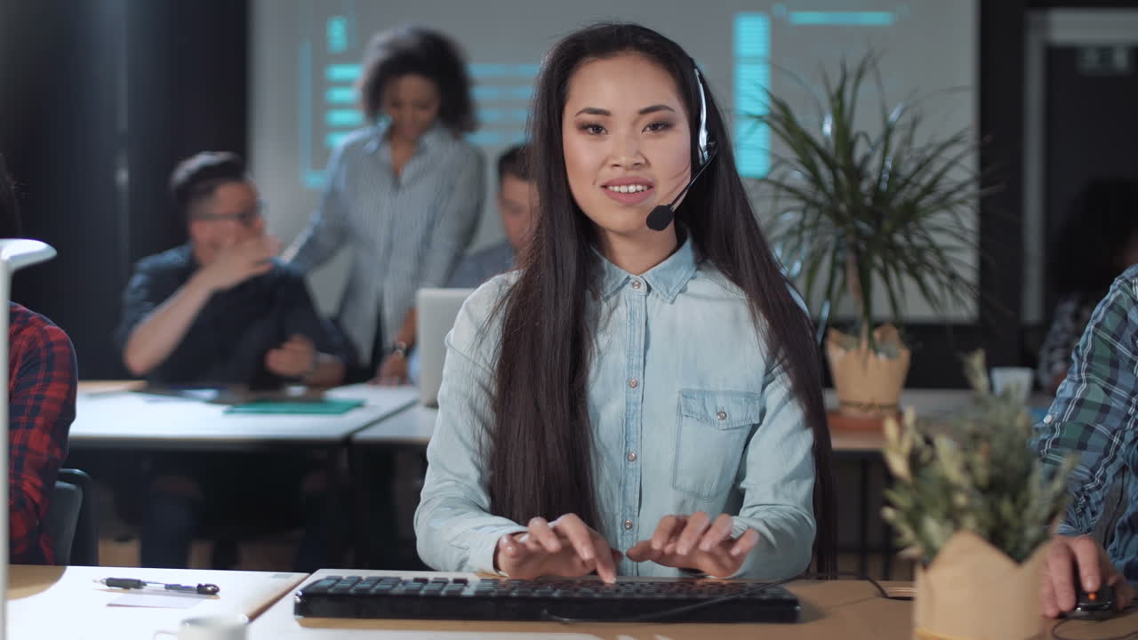 A young Asian woman working as a call center agent in an office environment