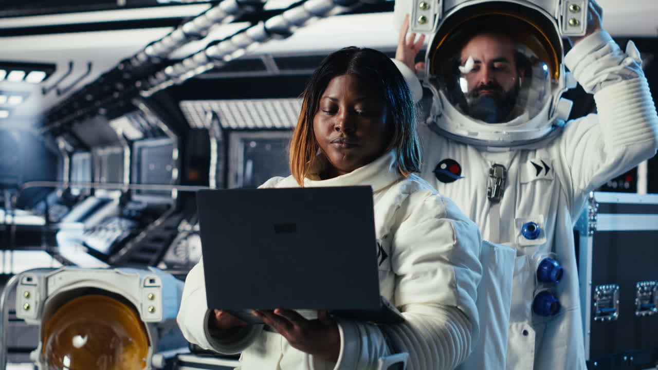 Cosmonaut leaving starship after landing on planet, waving hand to colleague