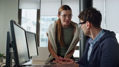 friendly managers looking computer in office. it man coaching discussing code