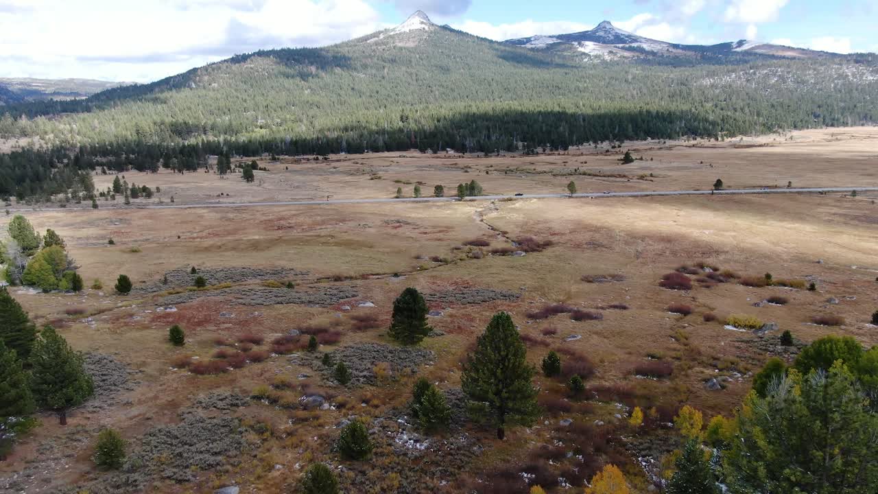 video panorámico de una carretera con coches conduciendo rodeados de montañas con picos nevados en tahoe en sierra nevada, california