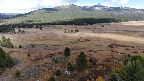 panoramic video of a road with cars driving through sorrounded by mountains with snowy peaks at tahoe in sierra nevada, california