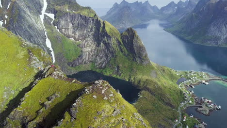 volando junto a dos personas de pie en la cima de la montaña en lofoten noruega