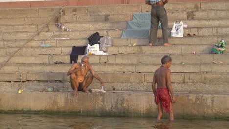 man brushing his teeth on a ganges ghat