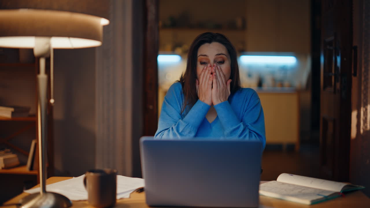 Freelancer receiving great news looking laptop at evening home workplace closeup