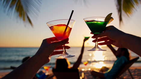 friends enjoying cocktails at sunset on the beach