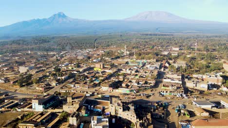 Sonnenaufgang-–-Kenia-Landschaft-Mit-Einem-Dorf,-Kilimandscharo-Und-Amboseli-Nationalpark-–-Verfolgung,-Drohnen-Luftaufnahme