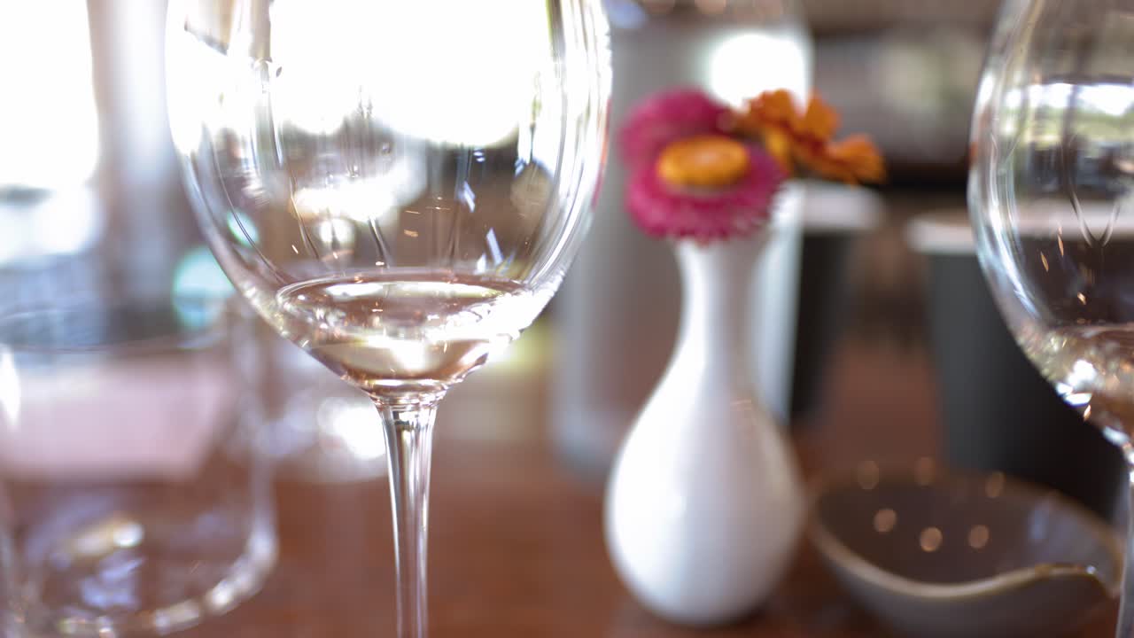 Statisk nærbillede af elegante vinglas og blomsterdekoration på et restaurantbord