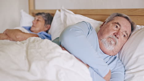 frustrated senior couple, bed