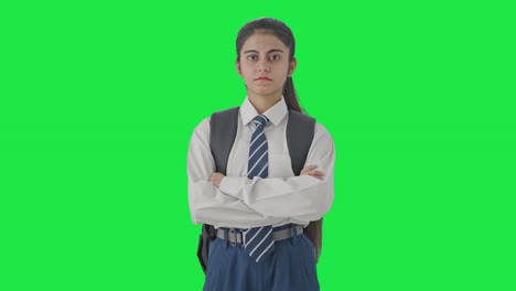 niña de escuela india segura de pie con las manos cruzadas pantalla verde