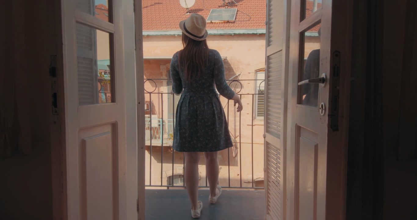 Woman in hat at the balcony