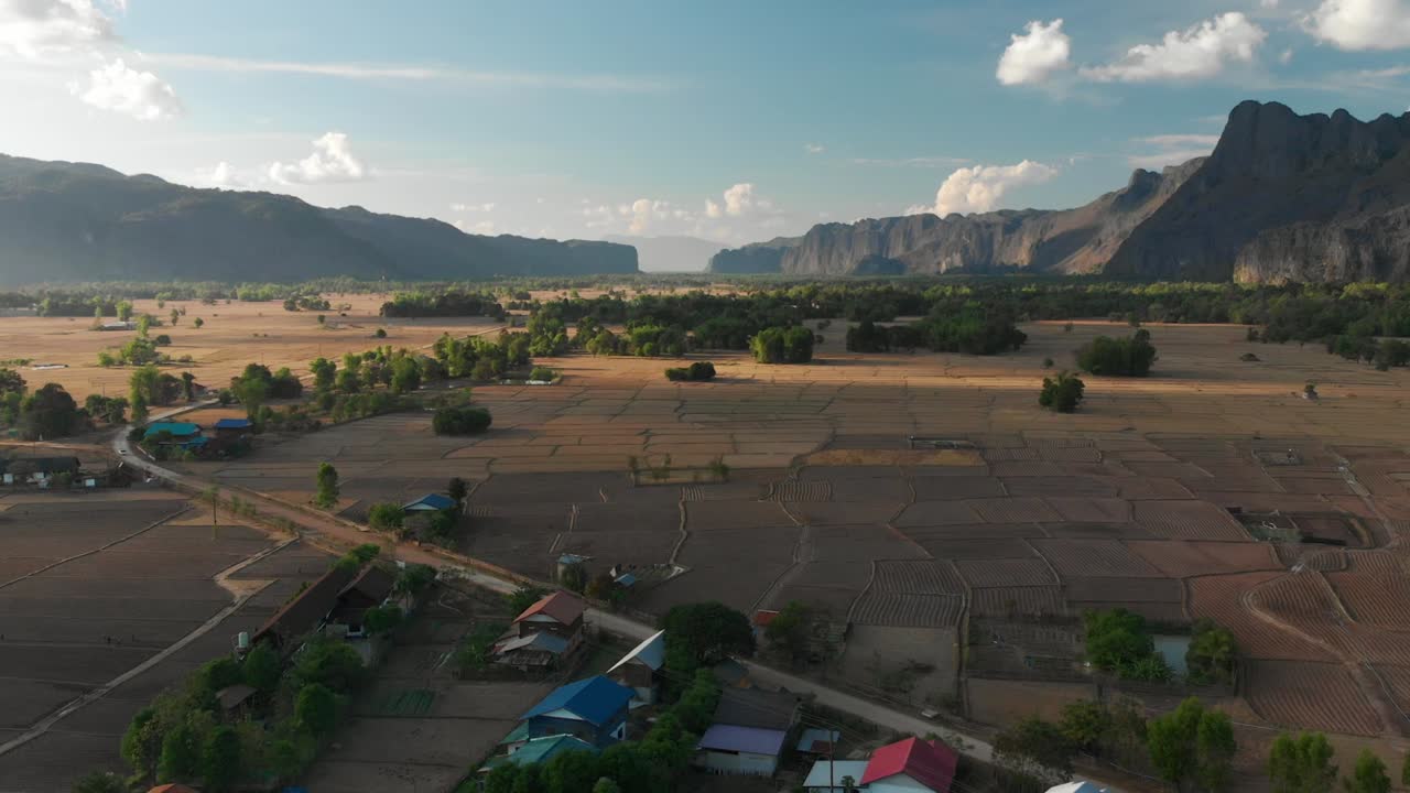 Vista aerea con drone di un villaggio vicino a Ban Gnang, Laos, che mostra campagna, campi e montagne.