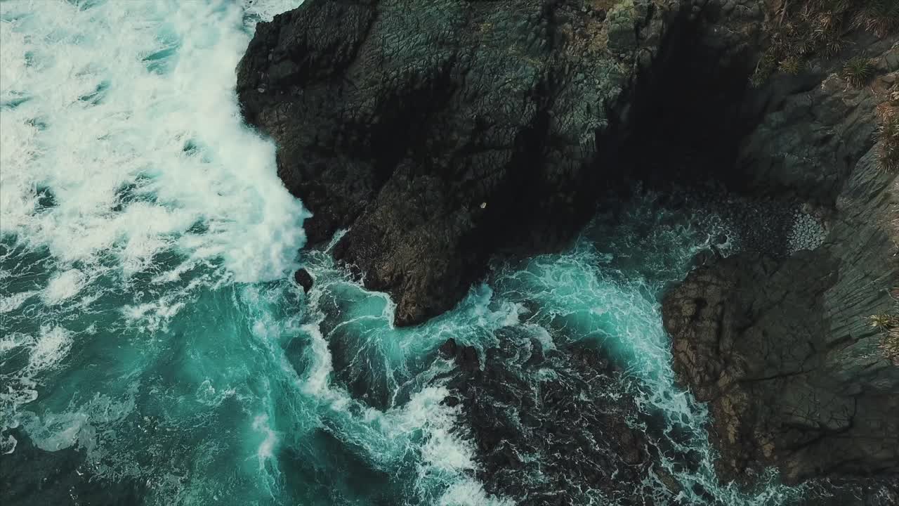 Wave crashing into volcanic rock