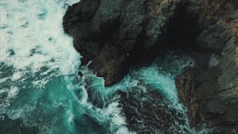 wave crashing into volcanic rock