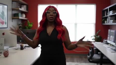 confident businesswoman demonstrating leadership skills in a modern office environment with a vibrant red accent wall and stylish décor