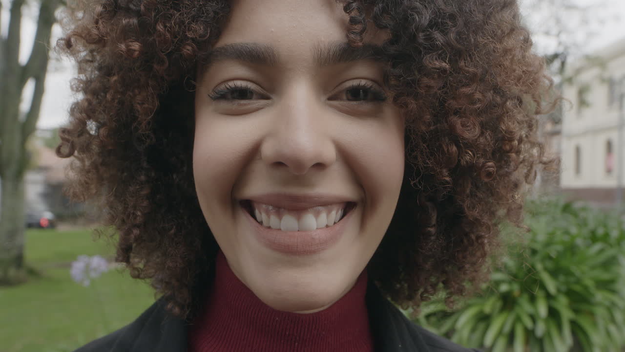 retrato de cerca de una atractiva mujer afroamericana abriendo los ojos y sonriendo