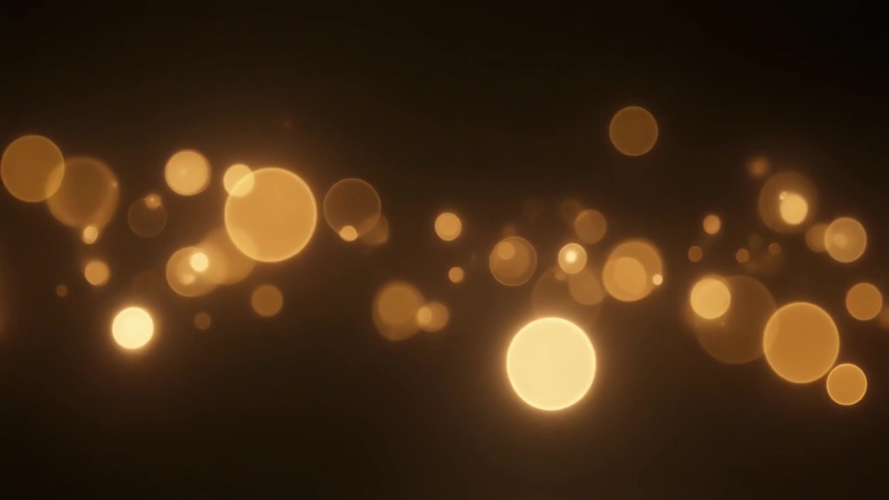 Kelluvat kultaiset bokeh-hiukkaset tummalla taustalla
