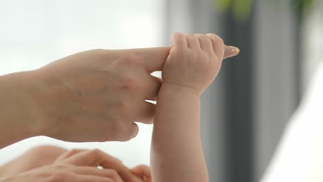 baby holding a mother's finger