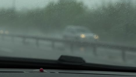 Coche-Pov-Conduciendo-Bajo-La-Lluvia-En-La-Autopista-Con-Faros-De-Coche-Con-Espejos-Retrovisores-Moviéndose-En-Cámara-Lenta