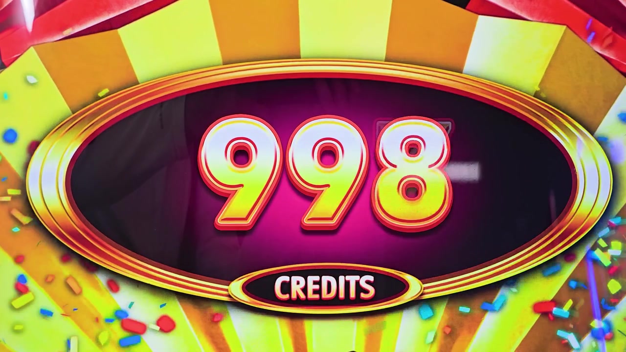 Close-up of winning slot machine animation with credits on screen, yellow gold highlights, colorful party graphics, and bright casino lighting for jackpot and gambling videos.