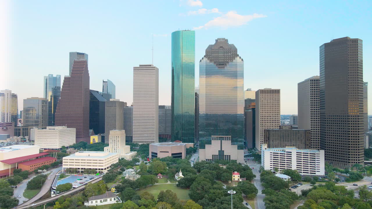 Ripresa aerea introduttiva con drone del centro di Houston in Texas. Ripresa aerea con effetto parallasse della città di Houston. Video drone 4K di grattacieli di Houston, Texas, cielo blu. Parco Sam Houston al tramonto