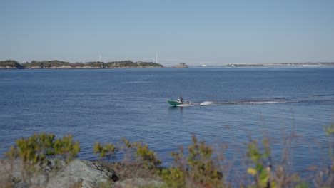 man driving a small boat in the ocean offshore in newport rhode island