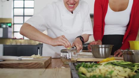 Caucasian-female-chef-teaching-diverse-group