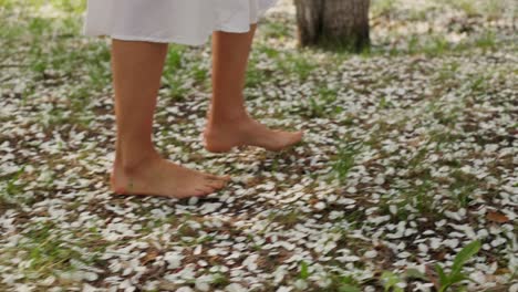woman walking barefoot on a flower-covered path