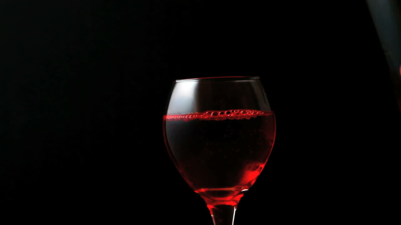bicchiere di vino rosso che viene versato