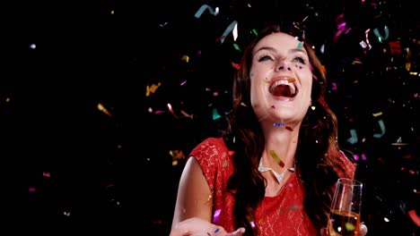 Excited-woman-with-champagne-glass-looking-at-the-confetti-4k